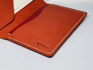 レッド色のヌメ革パスポートケースのアップ写真